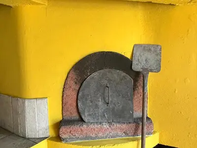 a yellow wall with a stone oven on it at Bela Vigia in Jardim do Mar
