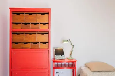 a red cabinet next to a red table with a lamp at Cantinho do Barreiro - Calheta in Calheta