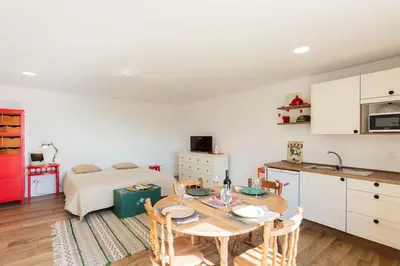 a kitchen and dining room with a table and a bed at Cantinho do Barreiro - Calheta in Calheta
