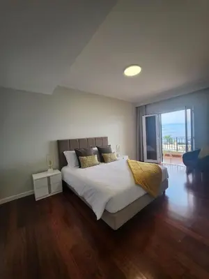 a bedroom with a large bed and a large window at Blue Diamond-seaview & free park in Funchal