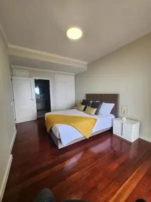 a bedroom with a large bed and a wooden floor at Blue Diamond-seaview & free park in Funchal