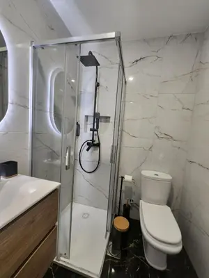 a white bathroom with a shower and a toilet at Blue Diamond-seaview & free park in Funchal