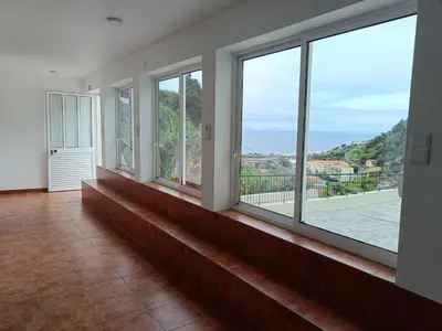 a room with windows with a view of the ocean at Ribeira Roots Residence in Santa Cruz