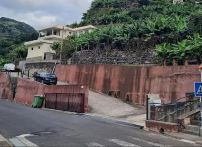 a car parked on a road next to a wall at Ribeira Roots Residence in Santa Cruz
