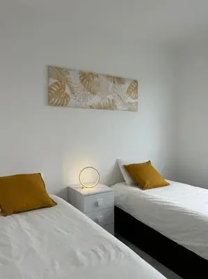 a bedroom with two beds and a nightstand between them at Golden Island in Porto Santo