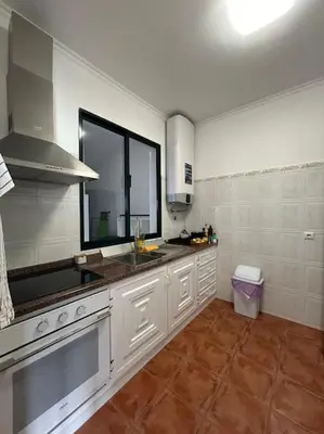 a kitchen with white cabinets and a sink and a window at Golden Island in Porto Santo