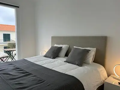 a bedroom with a bed with pillows and a balcony at Golden Island in Porto Santo