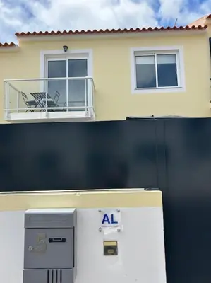 a house with a balcony and a air conditioner at Golden Island in Porto Santo