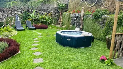 a garden with a hot tub in the grass at Casas das Hortas, Apartamento Vista Serra e Mar in Seixal
