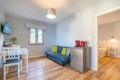 a living room with a blue couch and a table at Casas das Hortas, Apartamento Vista Serra e Mar in Seixal
