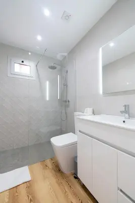 a white bathroom with a toilet and a sink at Casas das Hortas, Apartamento Vista Serra e Mar in Seixal