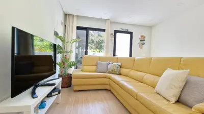 a living room with a yellow couch and a flat screen tv at Casa D'Além I & II by LovelyStay in Machico