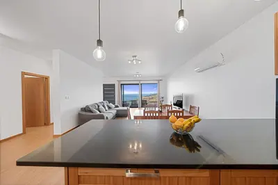 a kitchen and living room with a table with bananas on it at Calheta Paradise Holiday Home - Free Parking & Views in Arco da Calheta