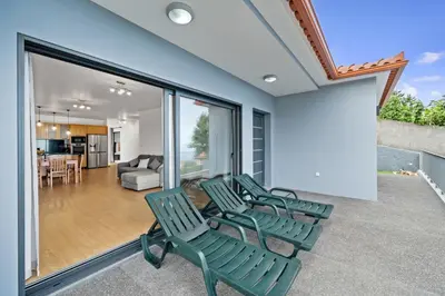 a group of green chairs sitting on a balcony at Calheta Paradise Holiday Home - Free Parking & Views in Arco da Calheta