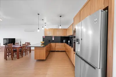 a kitchen with a stainless steel refrigerator and a table at Calheta Paradise Holiday Home - Free Parking & Views in Arco da Calheta