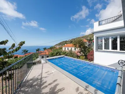 a villa with a swimming pool and a view of the ocean at Akivillas Calheta Aura in Arco da Calheta