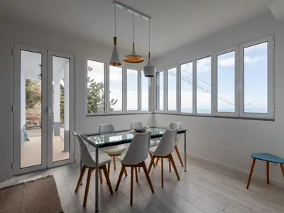 a dining room with a glass table and chairs at Akivillas Calheta Aura in Arco da Calheta