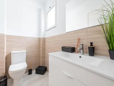 a bathroom with a white toilet and a sink at Akivillas Calheta Aura in Arco da Calheta