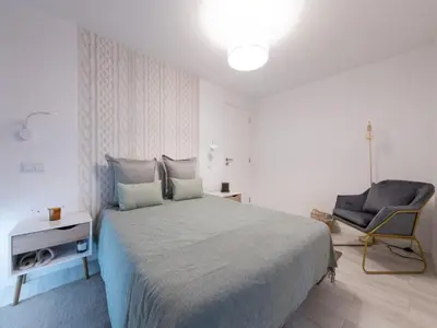 a bedroom with a large bed and a chair at Akivillas Calheta Aura in Arco da Calheta