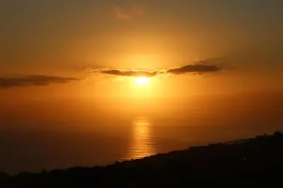 a sunset over the ocean with the sun in the sky at Casa Menezes Sunrise and Sunset Every Day in Calheta