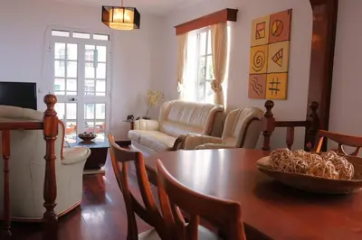 a living room with a table and chairs and a couch at Casa Menezes Sunrise and Sunset Every Day in Calheta