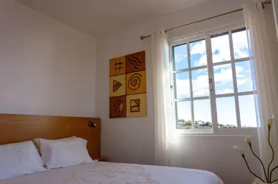 a bedroom with a bed and a window at Casa Menezes Sunrise and Sunset Every Day in Calheta