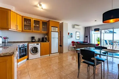 a kitchen and living room with a table and a dining room at Casa Flora, 2 quartos,vista mar in Arco da Calheta