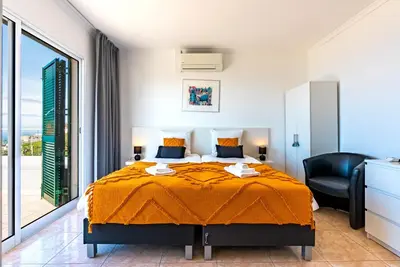 a bedroom with a bed and a large window at Casa Flora, 2 quartos,vista mar in Arco da Calheta