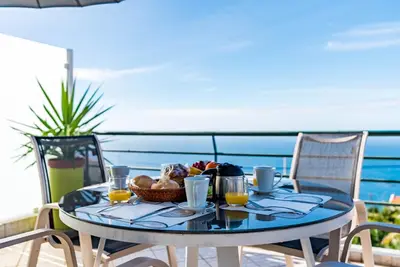 a living room with two couches and a table at Casa Flora, 2 quartos,vista mar in Arco da Calheta