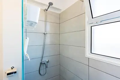 a shower in a bathroom with a window at Casa Flora, 2 quartos,vista mar in Arco da Calheta
