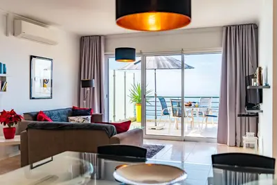 a kitchen with a glass table and blue chairs at Casa Flora, 2 quartos,vista mar in Arco da Calheta