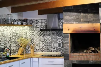 a kitchen with a fireplace with a tile wall at Casa d Avó 1937, By OP in Senhora do Rosário