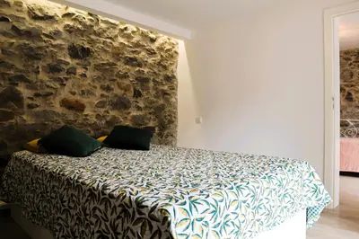 a bedroom with a bed with a stone wall at Casa d Avó 1937, By OP in Senhora do Rosário