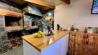 a kitchen with a counter with a stone fireplace at Casa d Avó 1937, By OP in Senhora do Rosário