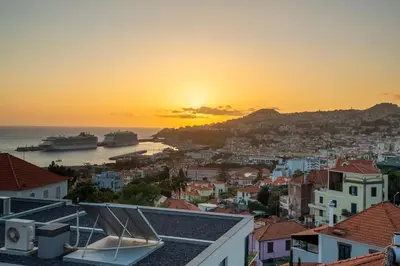 a view of the city at sunset at Villa Funchal in Funchal