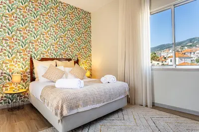 a bedroom with a bed with a large window at Villa Funchal in Funchal