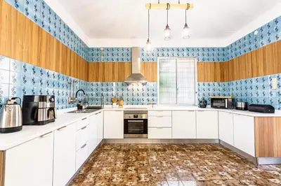 a kitchen with white cabinets and blue tiled walls at Villa Funchal in Funchal