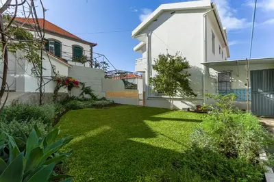 a garden with a lawn in front of a house at Villa Funchal in Funchal