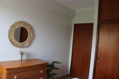 a room with a mirror on the wall and a dresser at Pé n' Areia Beach House Porto Santo in Porto Santo