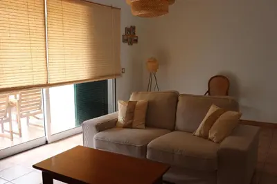 a living room with a couch and a table at Pé n' Areia Beach House Porto Santo in Porto Santo