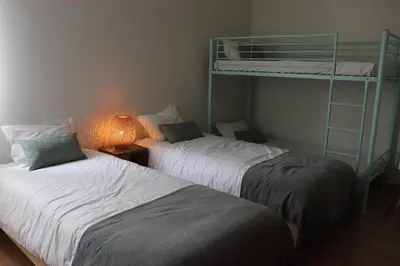 two beds in a room with a bunk bed at Pé n' Areia Beach House Porto Santo in Porto Santo