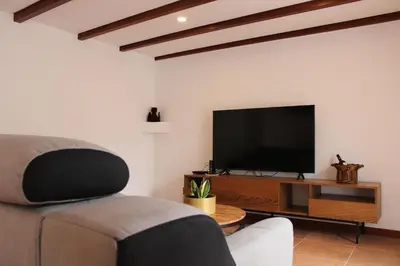 a living room with a couch and a flat screen tv at Casa da Ponta in Ponta do Pargo