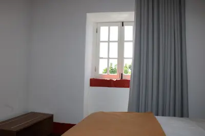 a bedroom with a bed and a window at Casa da Ponta in Ponta do Pargo
