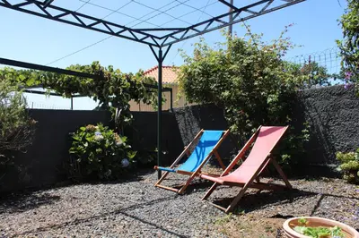two chairs in a garden with a pergola at Casa da Ponta in Ponta do Pargo