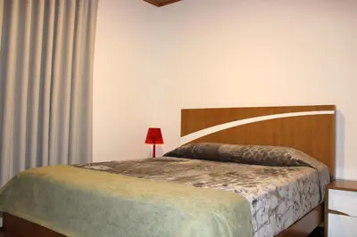 a bedroom with a large bed with a wooden headboard at Casa da Ponta in Ponta do Pargo
