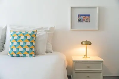 a room with a mirror and a table with a vase of flowers at The Plaza Apartment in Funchal