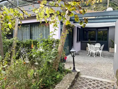 a patio of a house with a table and chairs at Marialina, By OP in São Vicente