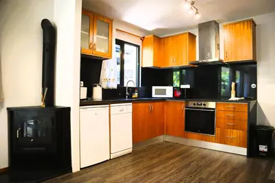 a kitchen with wooden cabinets and a black stove at Marialina, By OP in São Vicente