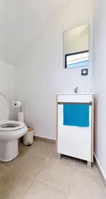 a white bathroom with a toilet and a sink at A Casa Azul - Arco da Calheta in Arco da Calheta