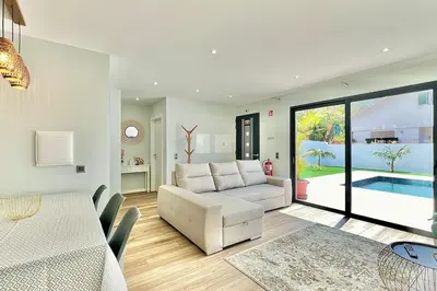 a living room with a white couch and a table at A Casa Azul - Arco da Calheta in Arco da Calheta